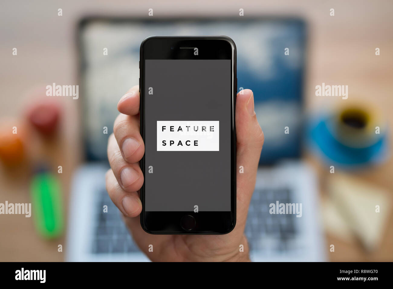 Ein Mann schaut auf seinem iPhone, zeigt die Funktion Raum Logo (nur redaktionelle Nutzung). Stockfoto