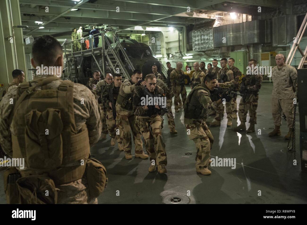 Us-Marines auf das Schwarze Meer die Drehkraft zugeordnet beobachten die Französische Marine einschalten fiktive Ziele an Bord das französische Schiff Mistral, im Mittelmeer, 3. März 2017, als Teil der Übung Jeanne d'Arc. Diese Übung bietet US-Marines die Möglichkeit, Kenntnisse im Kern Infanterie Fähigkeiten zu erhöhen und eine amphibische Mentalität entwickeln, während als eine zusammenhängende Einheit mit den französischen und britischen Militärs, um das Verständnis, wie die alliierten Streitkräfte betreiben und entwickeln die Kameradschaft zwischen unseren NATO-Partnern zu unterstützen ausgebildet werden. Stockfoto