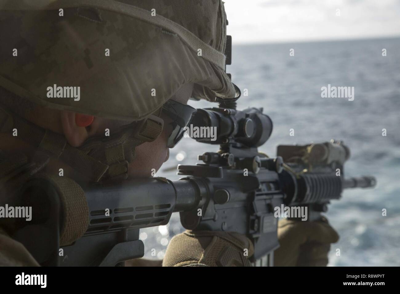 Ein US-Marines auf das Schwarze Meer die Drehkraft Sehenswürdigkeiten-in auf sein Ziel während einer Live-fire Palette an Bord das französische Schiff Mistral zugeordnet im Mittelmeer, 5. März 2017, als Teil der Übung Joanne d'Arc. Us-Marines gemeinsam durchgeführt, ein Feuer mit Französische Marine core Infanterie Fähigkeiten zu erhöhen, ist die Kenntnis der verschiedenen Waffensysteme erweitern und die Kameradschaft zwischen den NATO-Partnern zu entwickeln. Stockfoto