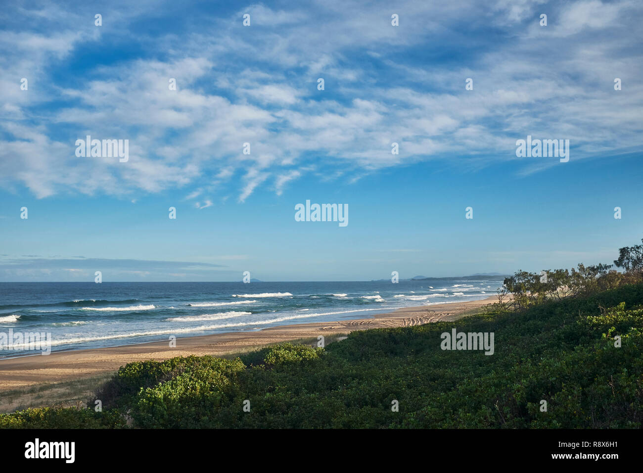 Blick auf eine einsame Strand an der australischen Küste mit einer kleinen Menge von Wolken im Himmel Stockfoto