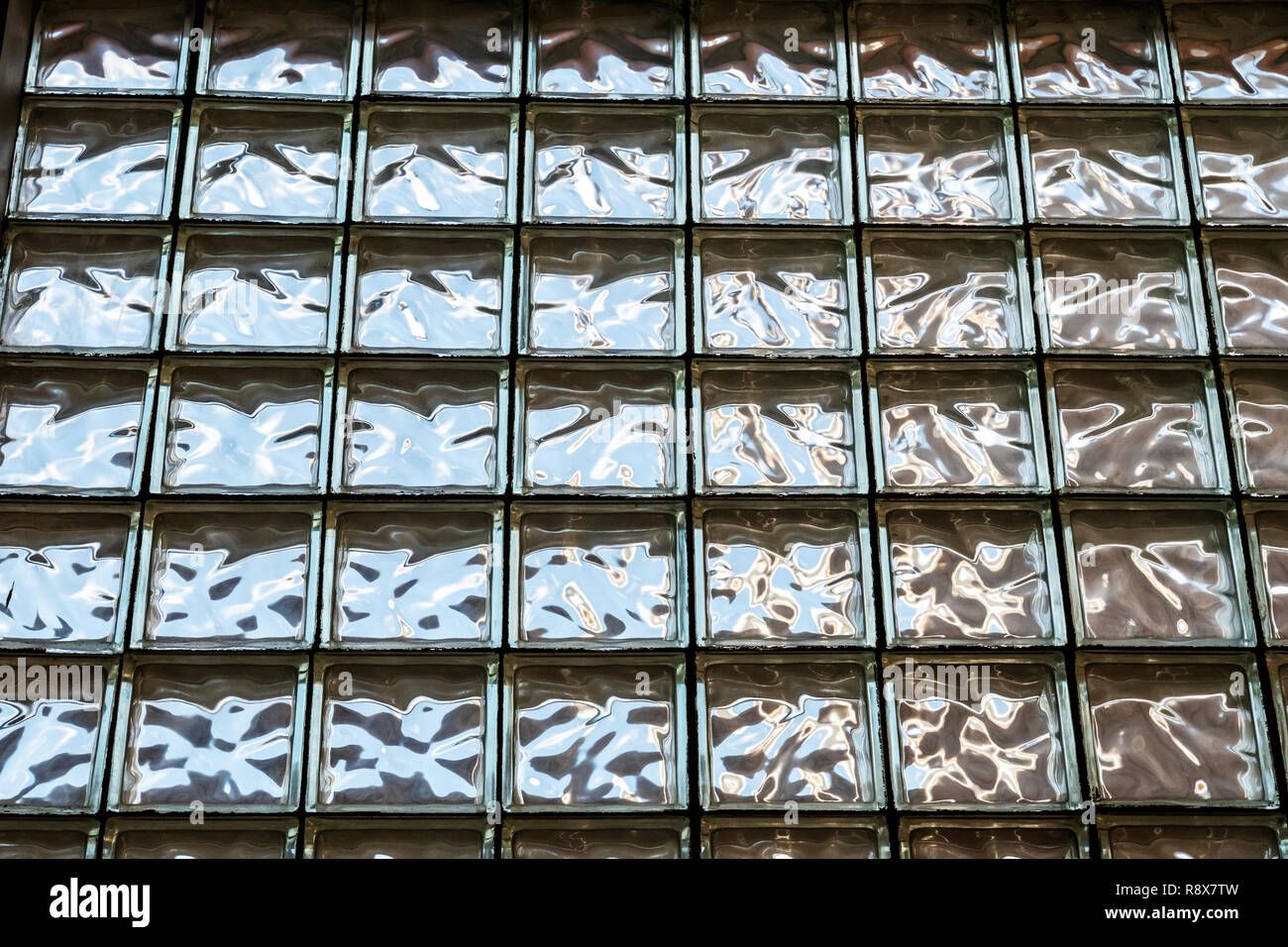 Bunte Lichtmuster auf architektonische Milchglas Blockwand Stockfoto