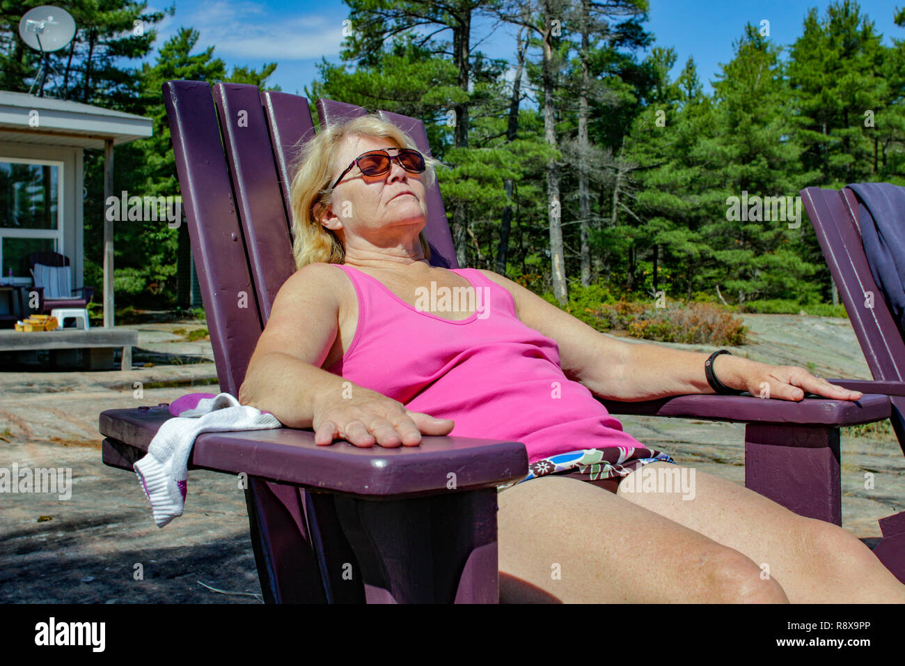 Reife Frau entspannen im Strandkorb an der Hütte 60 Jahre Stockfotografie -...