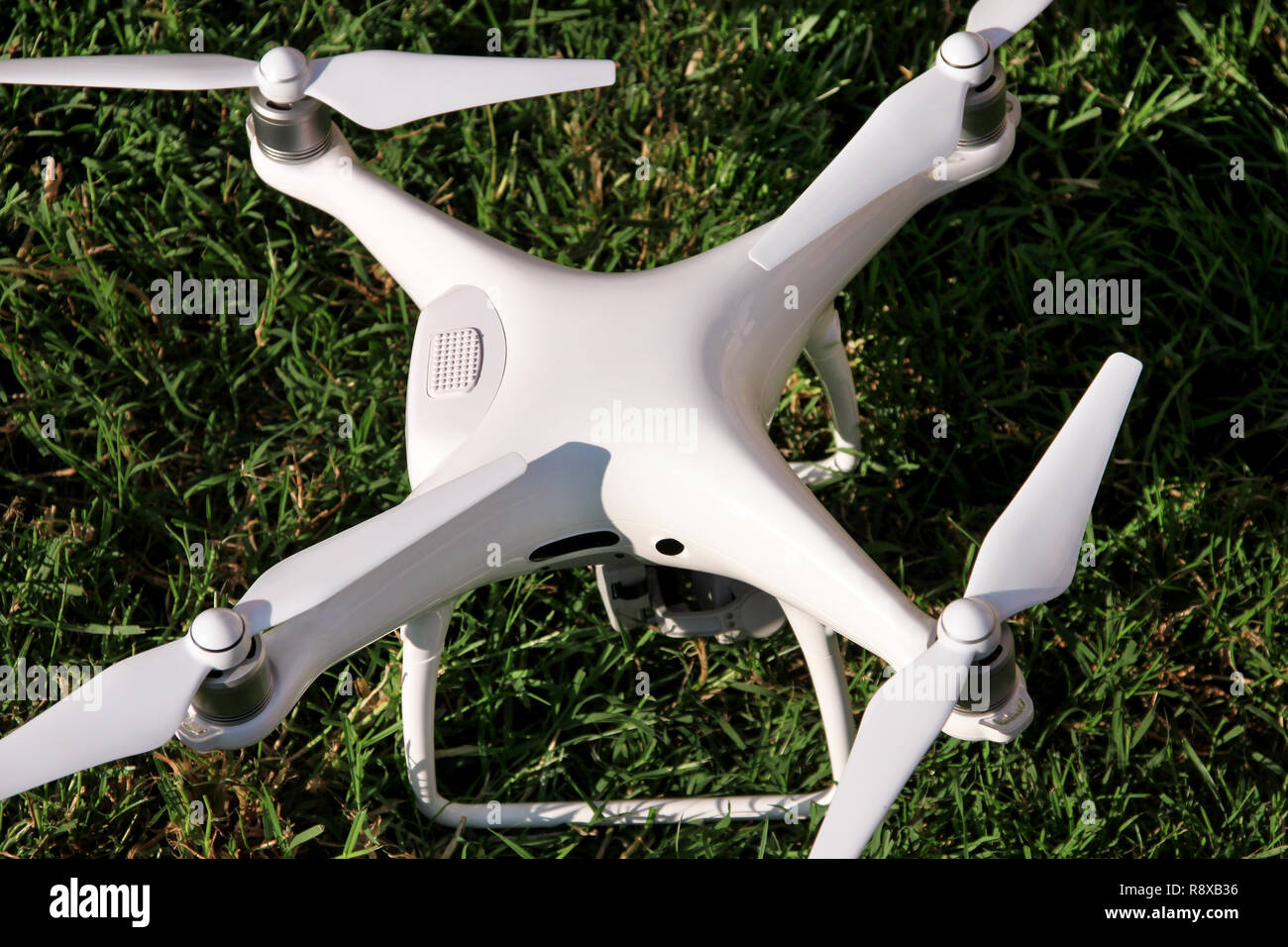Weiß quadcopter Drone mit 4K-Digitalkamera auf Gras ist bereit zum Abheben in die Luft zu fliegen, um zu fotografieren, aufnehmen Aufnahmen von oben. Drone. Stockfoto