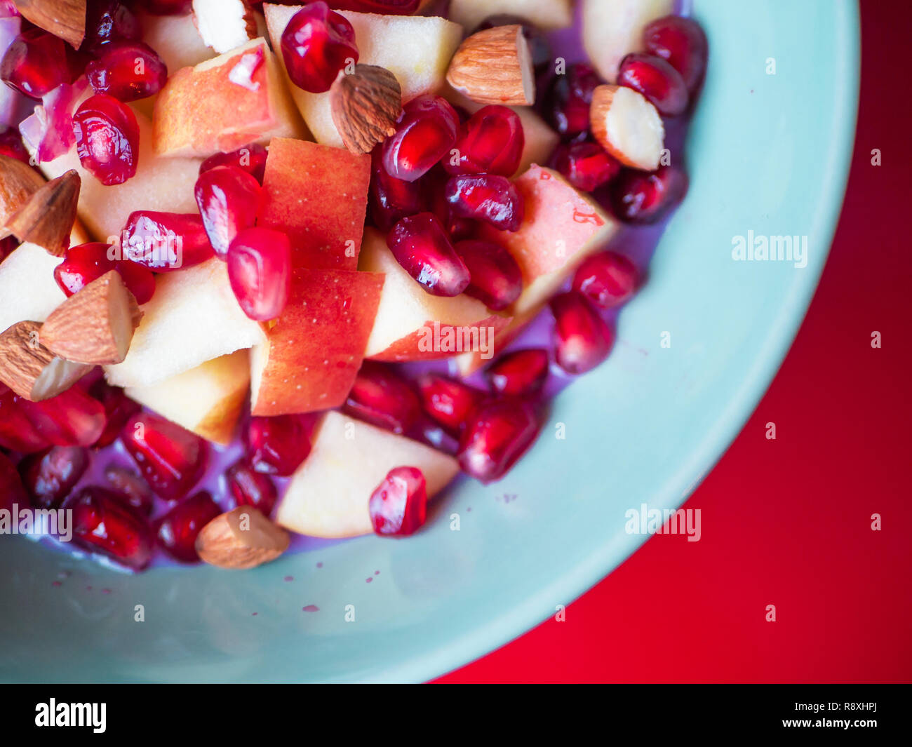 Blick von oben auf die leckeren Schüssel mit Granatapfel, Apfel und Mandeln Stockfoto