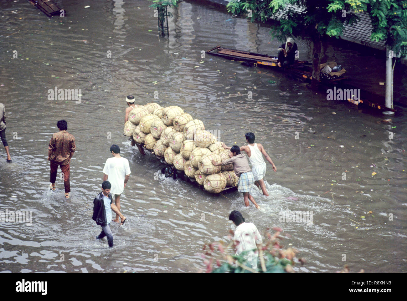 Hochwasser Aufgrund starker Regen, Männer Ziehen von schweren Karre auf überschwemmten Straßen, Bombay Mumbai, Maharashtra, Indien Stockfoto