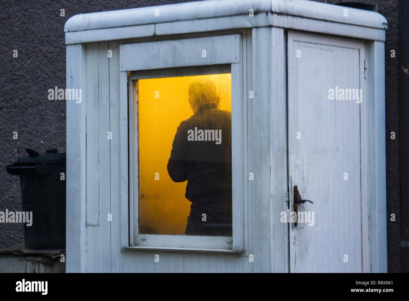 Ein älterer Mann Tarife sammeln in einen Parkplatz sucht Schutz in der kalten Winterluft in Pristina, Kosovo, 24.02.10. Während der Wintermonate, die Temperatur in der Balkanregion im Durchschnitt etwa 20 Grad Fahrenheit und unten. Stockfoto