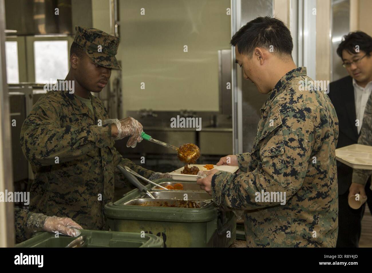 Us Marine Corps Lance Cpl. Dwayne Smith, ein cannoneer mit Sitz Batterie, 3.Bataillon, 12 Marines Orte Essen auf Tabletts während Chow in der Hijudai Manöver, Japan, 6. März 2017. Marinesoldaten und Matrosen an der Artillerie relocation Training Programm rechtzeitige und genaue Brände zu stellen militärische beruflichen Spezialgebiet Fähigkeiten, Zug Marines/Matrosen in gemeinsamen Fähigkeiten zu erhalten, und professionelle militärische Ausbildung für das allgemeine Ziel der Verbesserung der Bekämpfung der Betriebsbereitschaft und internationale Beziehungen zu fördern. Stockfoto