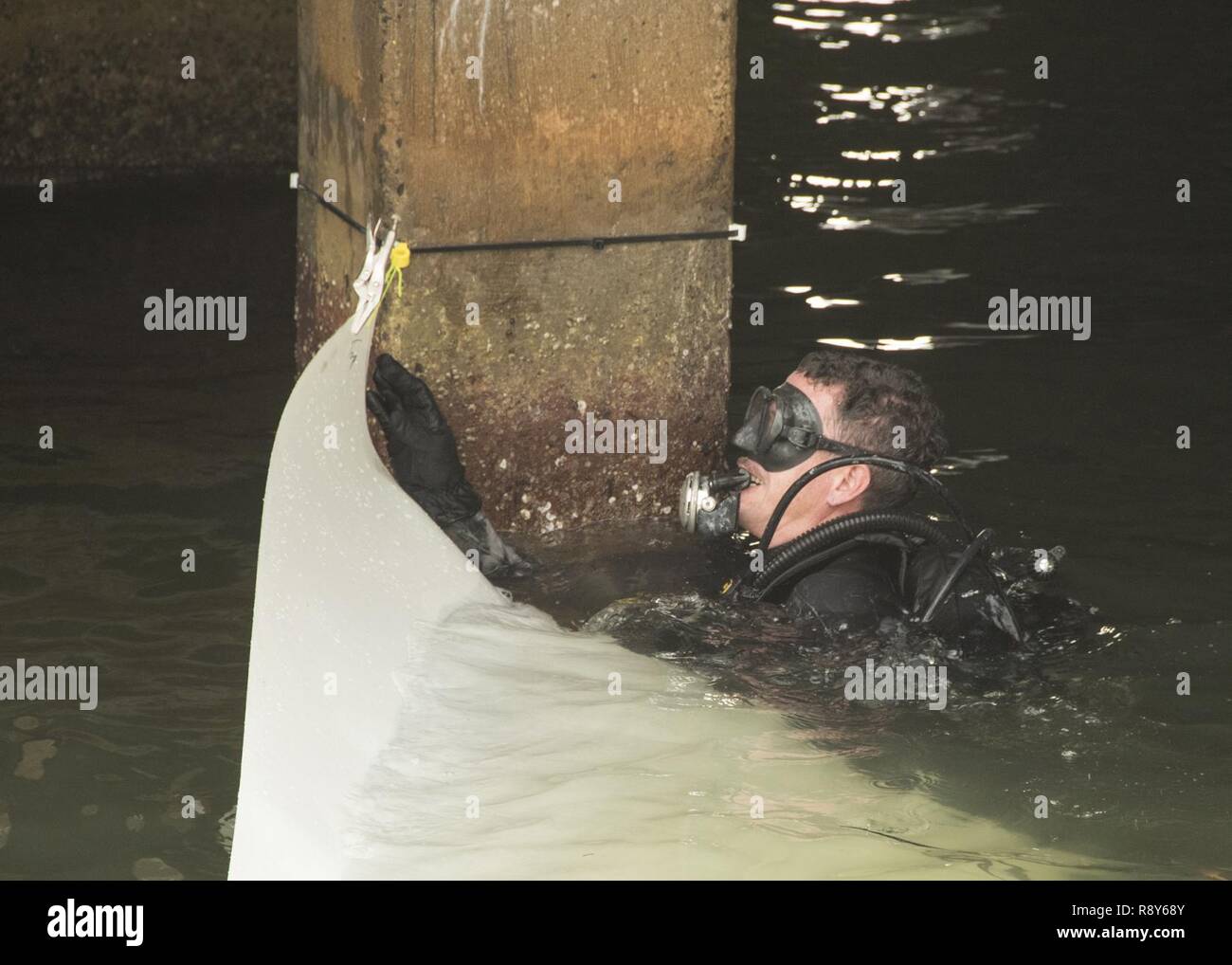 Spc. Michael Ritz, eine Armee Taucher mit 7 Tauchgang Loslösung, 84th Engineer Battalion, wickelt eine Reparatur Hülse um eine Pier Unterstützung haufen März 3. Stockfoto