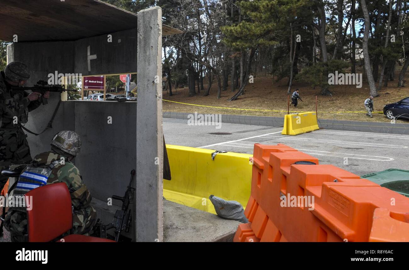 Flieger 1. Klasse Benjamin Hauber, 8 Security Forces Squadron Teammitglied, zieht die Sicherheit in einem Bunker als gegensätzliche Kräfte voraus, während Airman 1st Class Jeremy Parnell, 8 Security Forces Squadron defender, seine Waffe lädt, während Sie die Abdeckung in einem Bunker während der Übung Beverly Pack 17-2, ein Nein - Mitteilung Training bei Kunsan Air Base, der Republik Korea, 7. März 2017. Wir schulen zu beschäftigen airpower Aggression abzuschrecken, den Waffenstillstand zu erhalten und die Republik Korea verteidigen. Stockfoto