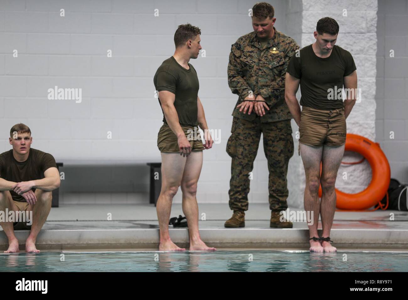 Ein Marine bereitet zu tauchen Sie ein in das Wasser mit seinen Handgelenken und Knöcheln während einer Klasse gebunden - Tauchen in Camp Lejeune, N.C., März 7, 2017. Die vor dem Tauchgang Klasse lehrt bekämpfen Schwimmkenntnisse, Atemtechniken, sowie geistige und körperliche Konditionierung Marines für Kämpfer Taucher Kurs vorbereiten können. Die Marines sind mit 2 Reconnaissance Battalion, 2nd Marine Division. Stockfoto