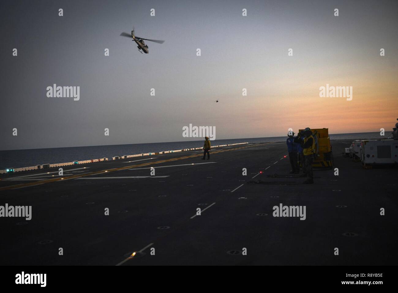 Atlantik (9. März 2017) - Segler beobachten Flugbetrieb als AH-1W SuperCobra, zugeordnet zu den Marine Light Attack Helicopter Squadron 167 (HMLA-167), off (aus) aus dem Flight Deck der Amphibisches Schiff USS Iwo Jima (LHD7). Das Schiff ist unterwegs eine Reihe von Qualifikationen und Zertifizierungen als Teil des grundlegenden Phase der Ausbildung in Vorbereitung auf die künftige Operationen und Bereitstellungen. Stockfoto