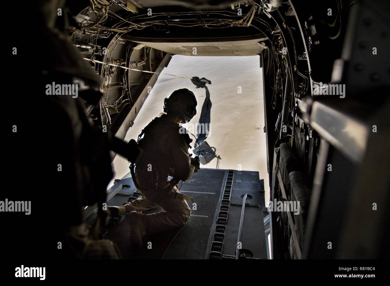 Ein US-Marine, mit Marine Medium Tiltrotar Squadron - 165 (VMM-165), einen Fallschirm Bündel auf der Rückseite eine MV-22 Osprey bei einer gemeinsamen airdrop Mission in Südwestasien, auf März 9, 2017. Stockfoto