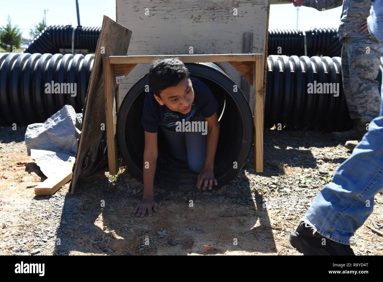 Ein Student aus Studien Club von Winston-Salem North Carolina klettert aus der Ausfahrt eines Tunnels, geschlossenen Räumen, auf einer Basis Tour an der North Carolina Air National Guard Base, Stanley County Airport, New London N.C., 8. März 2017 simulieren soll. Dreißig Schüler der 7. und 8. Klasse sind, dass alle Mitglieder eines Clubs Sozialkunde ByJennifer Scott die Ehefrau von Master Sergeant Brandon Scott der 118. hoch-und Tiefbau-Staffel lief. Stockfoto