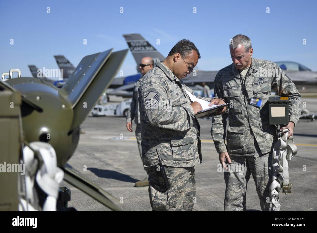 Us Air Force Master Sgt. Anthony King, Links, und Tech. Sgt. Sherman Padgett, der 169Th Maintenance Group, diskutieren, die die Verteilung der Bomben zu Kampfjets in der Tyndall Air Force Base in Florida am März 11, 2017 diskutieren. Mehr als 200 Flieger von der 169th Fighter Wing, South Carolina Air National Guard eingesetzt werden für die Waffensysteme Auswertung Programms (WSEP). Der WSEP Zweck ist die Fähigkeit einer Einheit, um effektiv Munition durch alle Stadien liefern zu bewerten, von Munition, Waffen laden auf das tatsächliche Start- oder Fallenlassen der Waffen aus dem Flugzeug zu bauen. Stockfoto