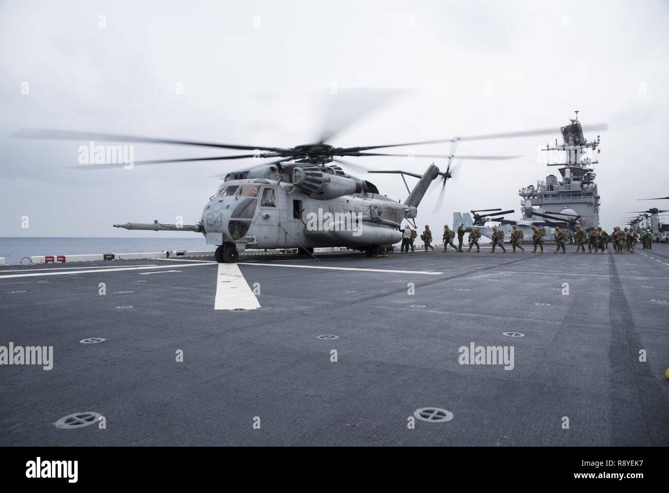 EAST CHINA SEA (16. März 2017) Marines, zugeordnet zu den 31 Marine Expeditionary Unit (MEU), begeben Sie sich Ein CH-53E Super Stallion, zugeordnet zu den "Flying Tigers" der Marine Medium Tiltrotor Squadron (VMM) 262, auf dem Flugdeck des Amphibious Assault ship USS BONHOMME RICHARD (LHD6) während einer Air Assault Übung in der Unterstützung von Amphibischen integration Training (AIT). AIT ist so ausgelegt, dass alle Elemente der Bonhomme Richard Expeditionary Strike Group (BHR ESG) und 31 MEU ihre Fähigkeit zur Planung und Mission wesentliche Aufgaben ausführen, um Test zu integrieren. Bonhomme Richard, dem Flaggschiff der BHR ESG, mit Stockfoto