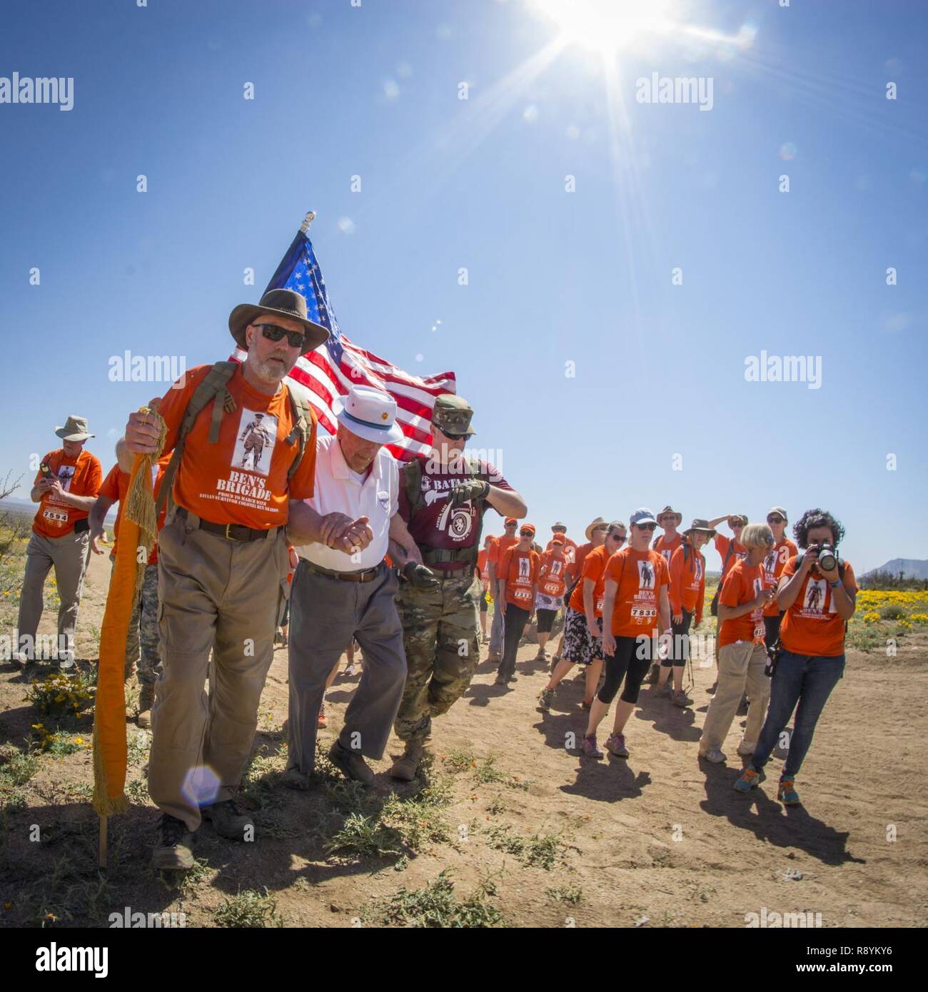 Pensionierte US-Army Oberst Ben Skardon, 99, ein Überlebender des Bataan Death March, Spaziergänge unter einer flammenden California Sun unterstützt durch die Mitglieder seiner treuen Support Team, Ben's Brigade - eine Gruppe von 64 Familie, Freunde, ehemalige Clemson University Studenten seines und Angehörigen seiner Mitbürger prisonors des Krieges - während der bataan Gedenkstätte Todesmarsch im White Sands Missile Range, N.M., 19. März 2017. Skardon ist der einzige Überlebende der echten Bataan Death March, die in der Gedenkstätte März Spaziergänge. Dies war der zehnte Zeit nahm Er, und Er hat ging Acht und eine halbe Meilen jeden Zeit. Stockfoto