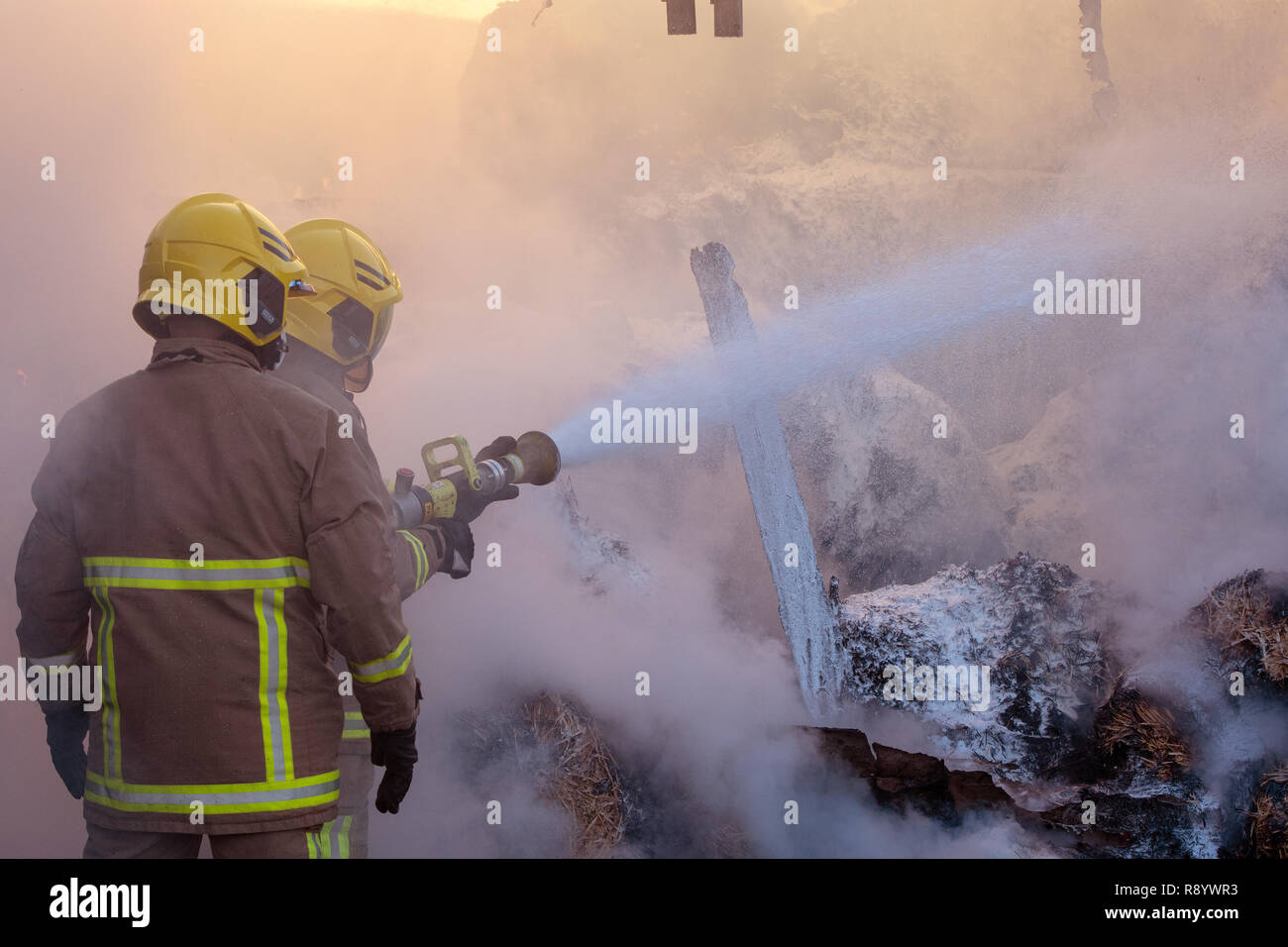 Feuerwehrleute kämpfen eine Scheune Feuer, Cumbria, Großbritannien Stockfoto