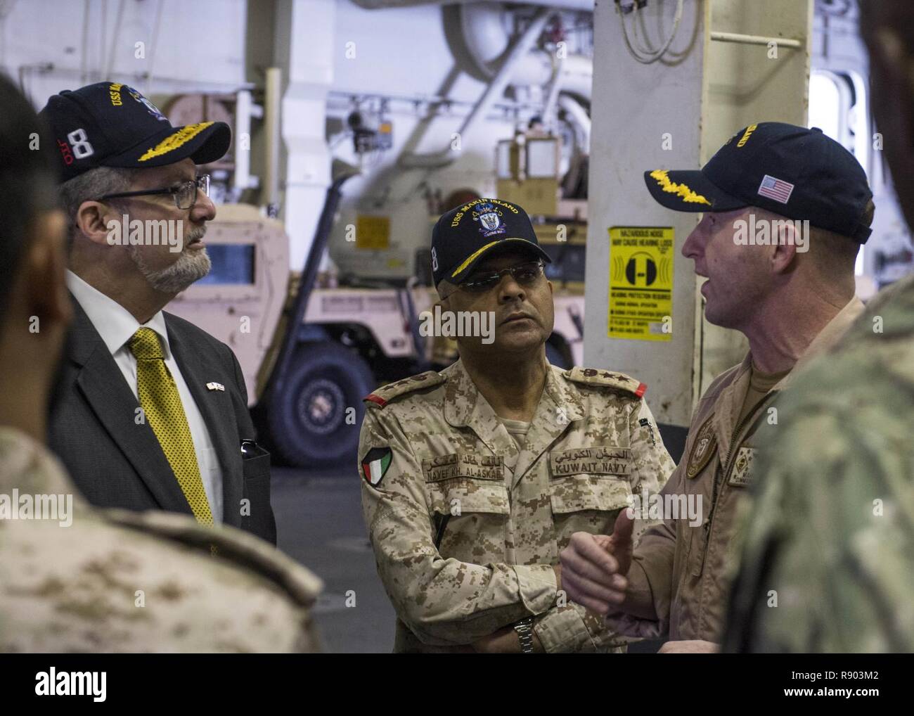 Arabischen Golf (15. März 2017) US-Botschafter in Kuwait Lawrence R. Silverman, Links, und Kuwait Marine Oberst Nayef al-Askar, Center, Tour der oberen Fahrzeug Lagerbereich des Amphibious Assault ship USS Makin Island (LHD8) mit befehlshabenden Offizier, Kapitän Mark A. Melson. Makin Island ist in die USA 5 Flotte Bereich für Maßnahmen zur Erhöhung der Sicherheit des Seeverkehrs auf die Verbündeten und Partnern zu beruhigen bereitgestellt, und der Freiheit der Schiffahrt und des freien Handels in der Region erhalten. Stockfoto