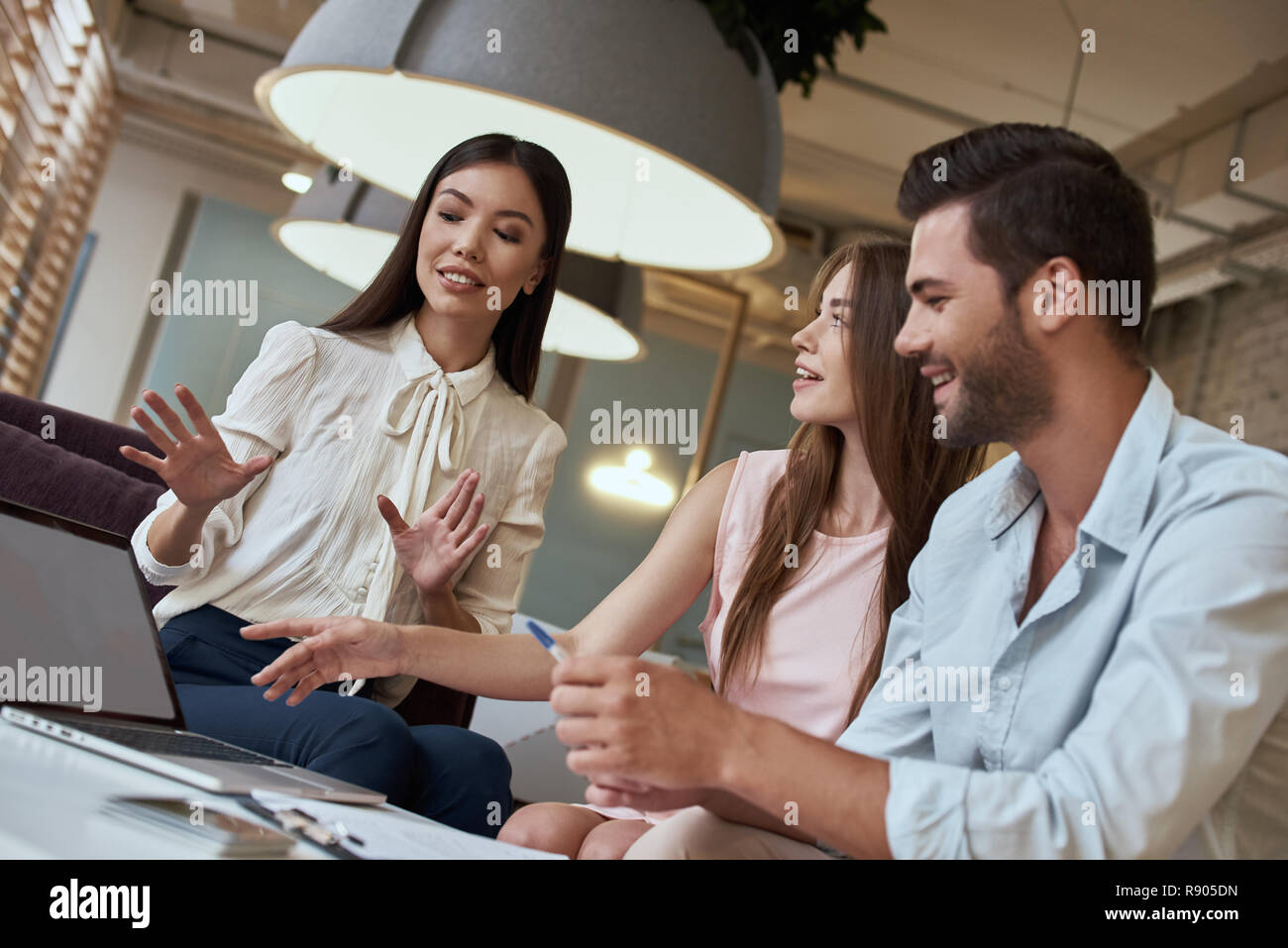Junges Paar in einer Tour Agentur hören Vorschlagen von Reisebüro Stockfoto