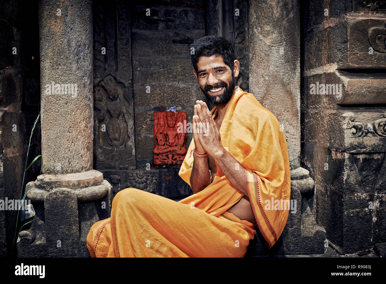 Naggar (Kullu Tal), Nord Indien - Juli 2013. Lächelnd indischen Brahmanen. sitzen in der Nähe der Tempel von Lord Krishna. Die Hände gefaltet in namaste Mudra. Stockfoto