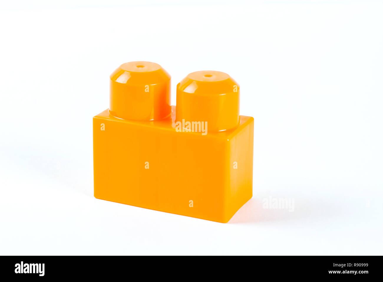 Orange Kunststoff Baustein auf weißem Hintergrund Stockfoto