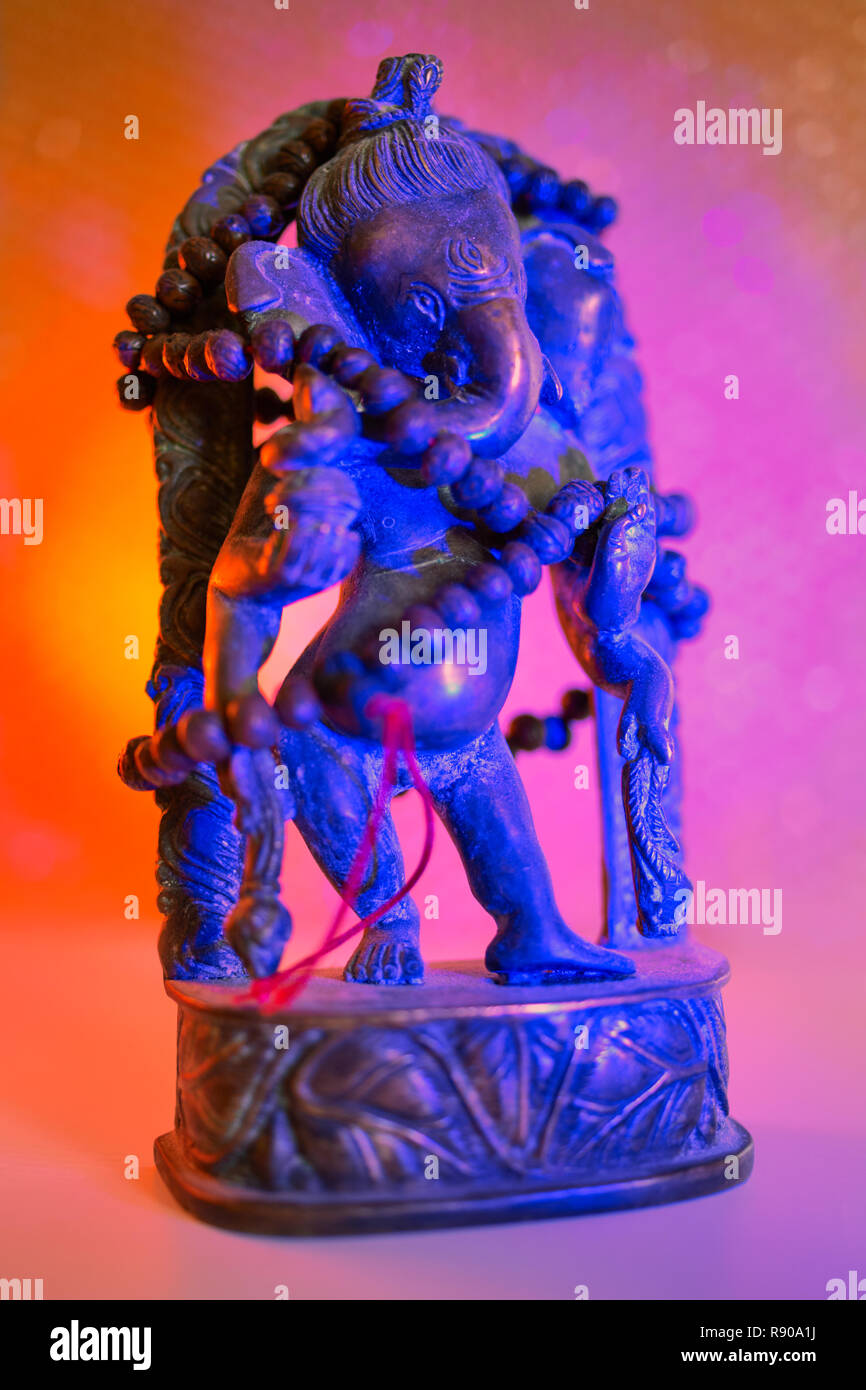 Hindu Gott - Lord Ganesha mit rudraksha Rosenkranz in ein buntes Licht. Bunte Foto der Gottheit Ganesha whit blured Hintergrund. Stockfoto