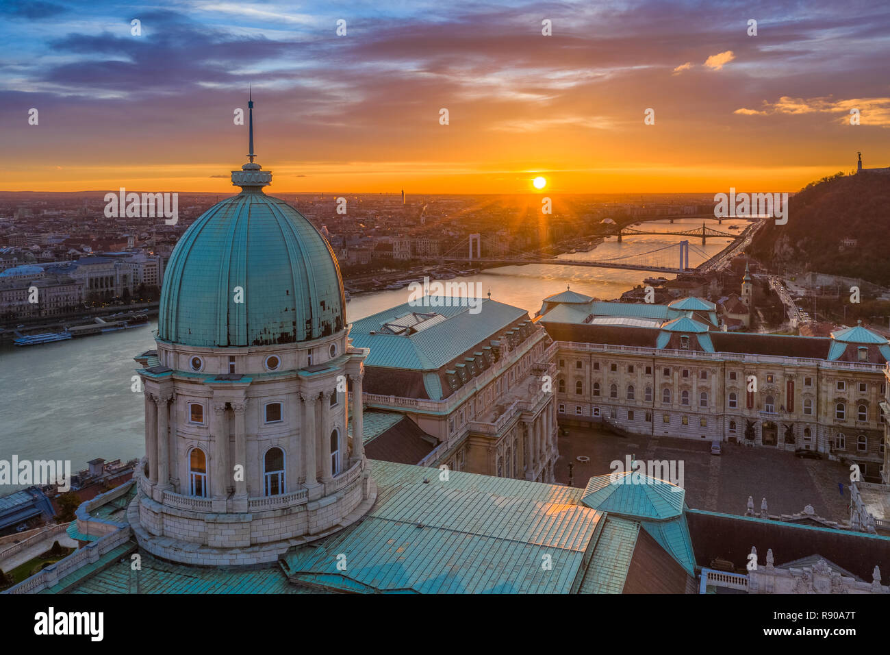 Budapest, Ungarn - Luftbild der Kuppel der Budaer Burg Royal Palace bei Sonnenaufgang mit Liberty Bridge, Elisabeth Brücke und die Freiheitsstatue Stockfoto