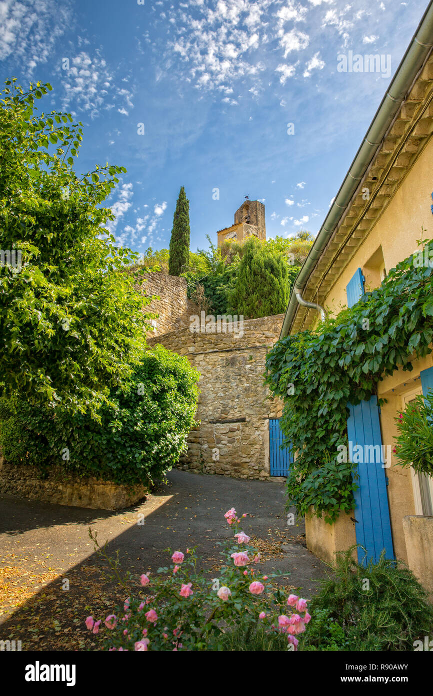 In Lourmarin, Provence, Luberon, Vaucluse, Frankreich - Mai 30, 2017: idyllische Gasse mit Blick auf den alten Kirchturm in Lourmarin Stockfoto