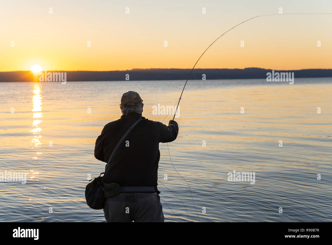 Eine Silhouette der Fliegenfischer Casting für Lachs und searun Küsten Halsabschneider Forellen aus einem Salz Wasser Strand an der Westküste der USA Stockfoto