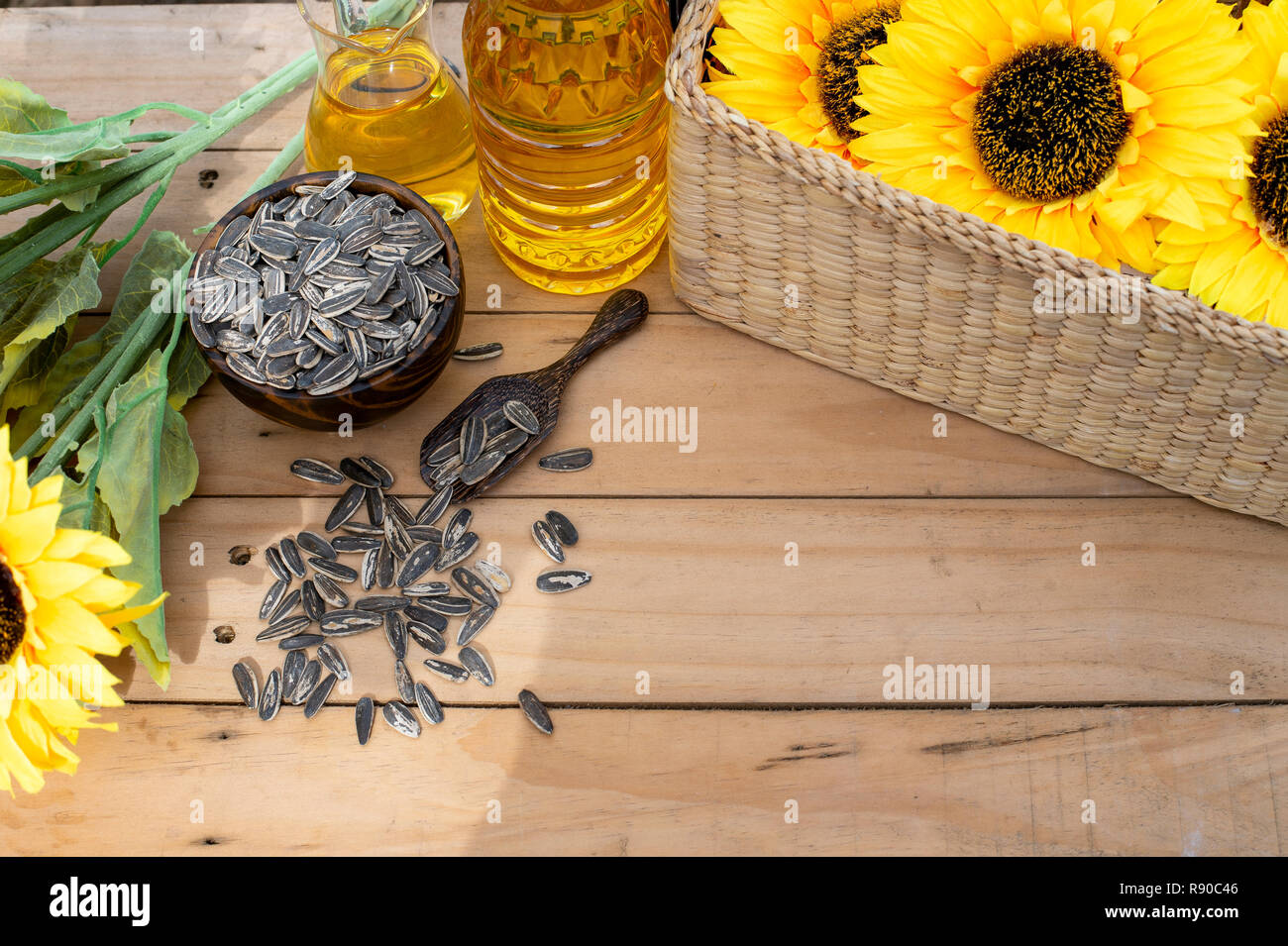 Bio Sonnenblumenöl in einem kleinen Glas Glas mit Sonnenblumenkernen und Sonne Blumen. Im Freien - Bild Stockfoto