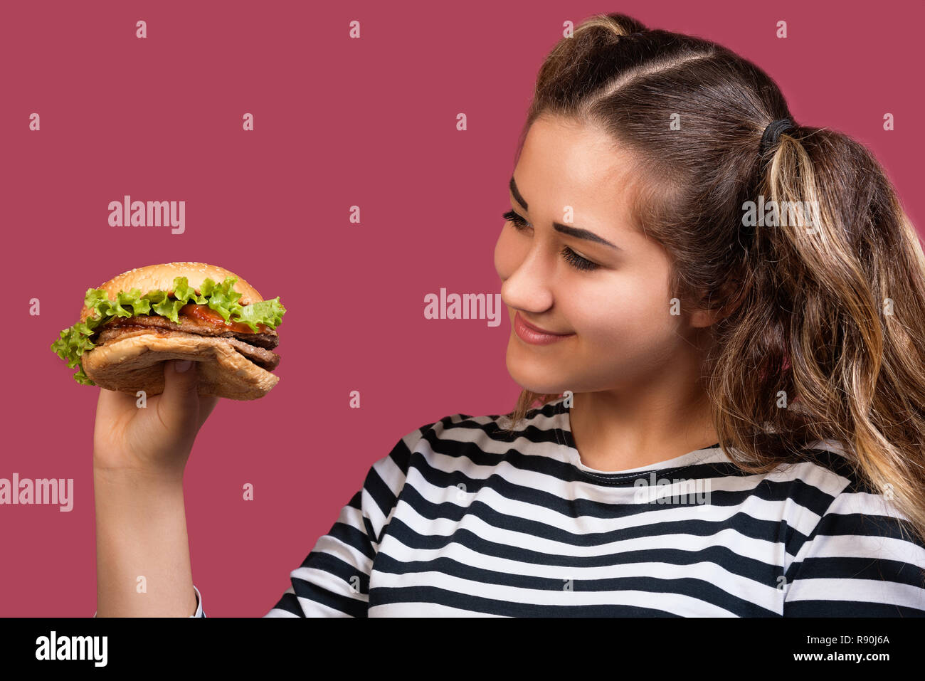 Close up Portrait von coolen Mädchen mit pferdeschwänze auf Hamburger über bunte rosa Hintergrund Stockfoto
