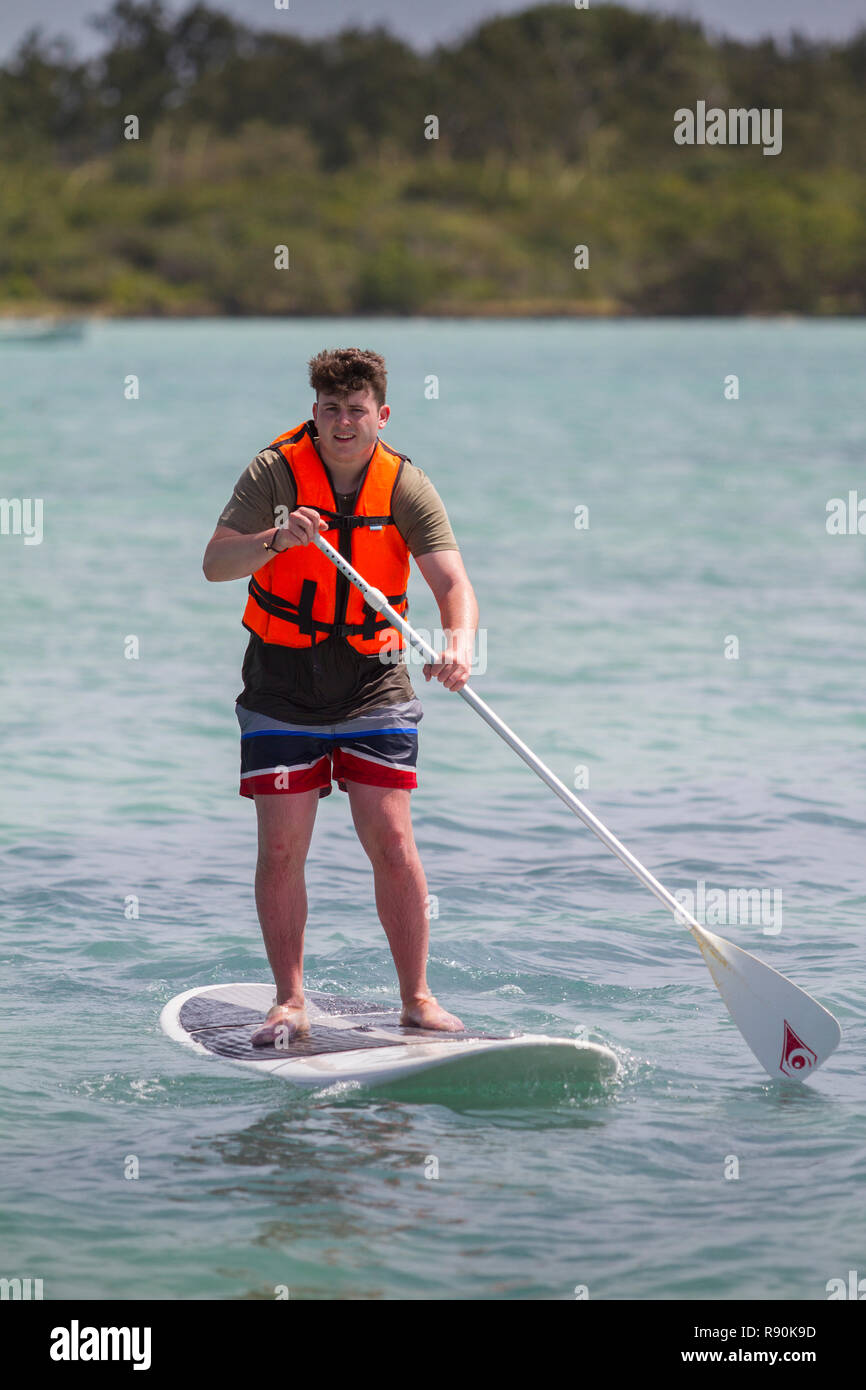 Young Boys auf Stand-up Paddle Boards mit Leben Bewahrer Stockfoto