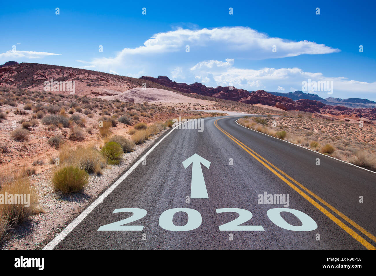 Das Jahr 2020 auf eine leere Straße in der Wüste von Nevada, USA geschrieben. Ein Pfeil zeigt in die Zukunft. Stockfoto