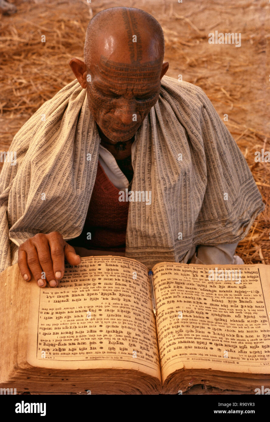 Eine Ramnaami Priester mit seiner tätowierten Gesicht lesen' Ram Charitra Manas' ihre heilige Schrift, zentrale Indien Stockfoto