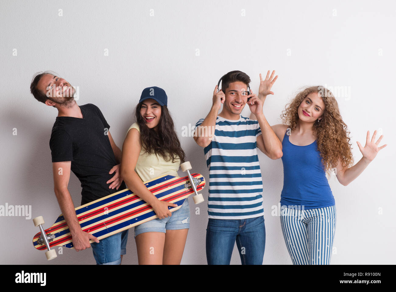 Portrait von freudige junge Gruppe von Freunden mit Longboard stehen in einem Studio. Stockfoto
