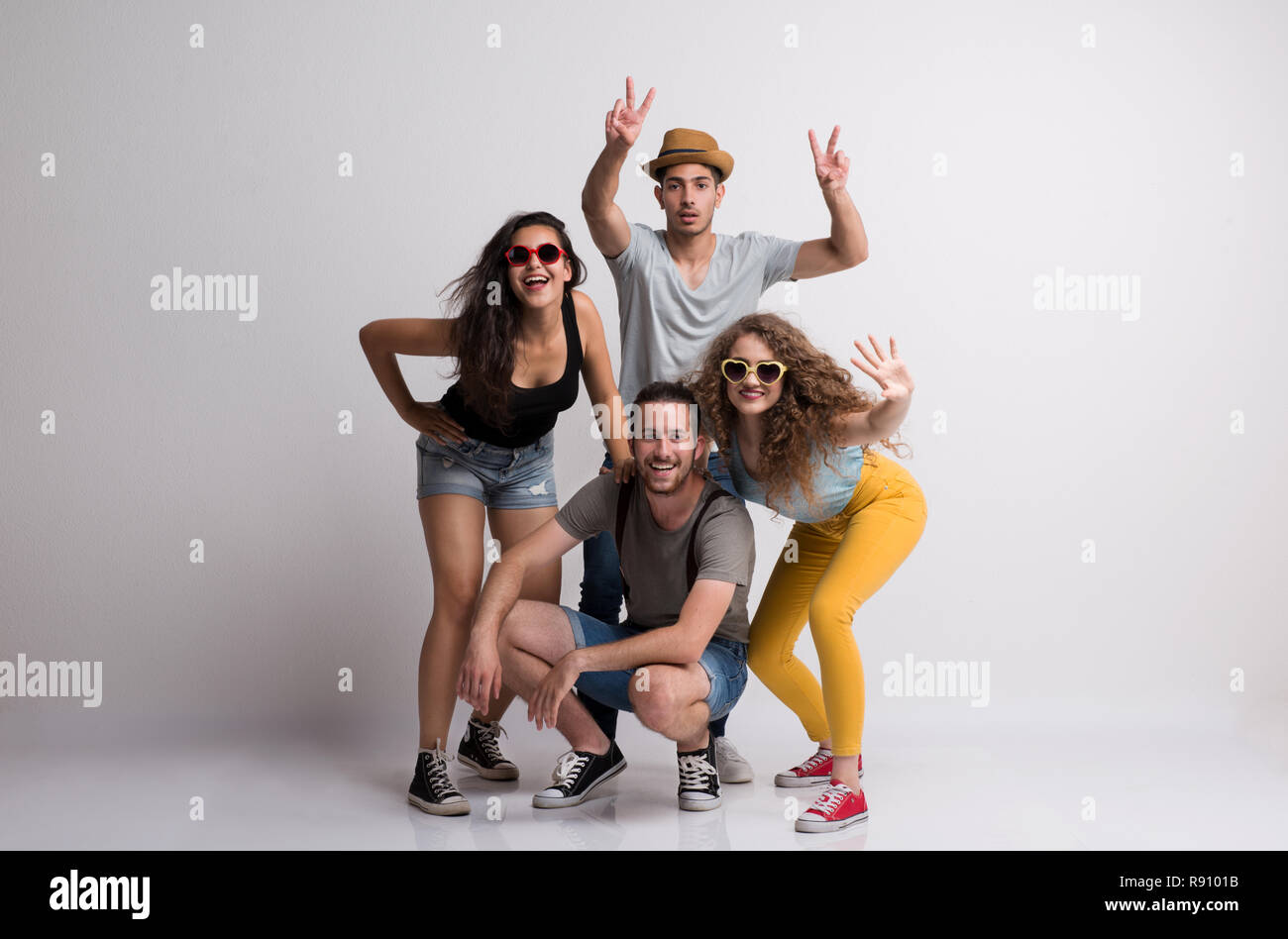 Portrait von freudige junge Gruppe von Freunden, mit Hut und Sonnenbrille in einem Studio. Stockfoto