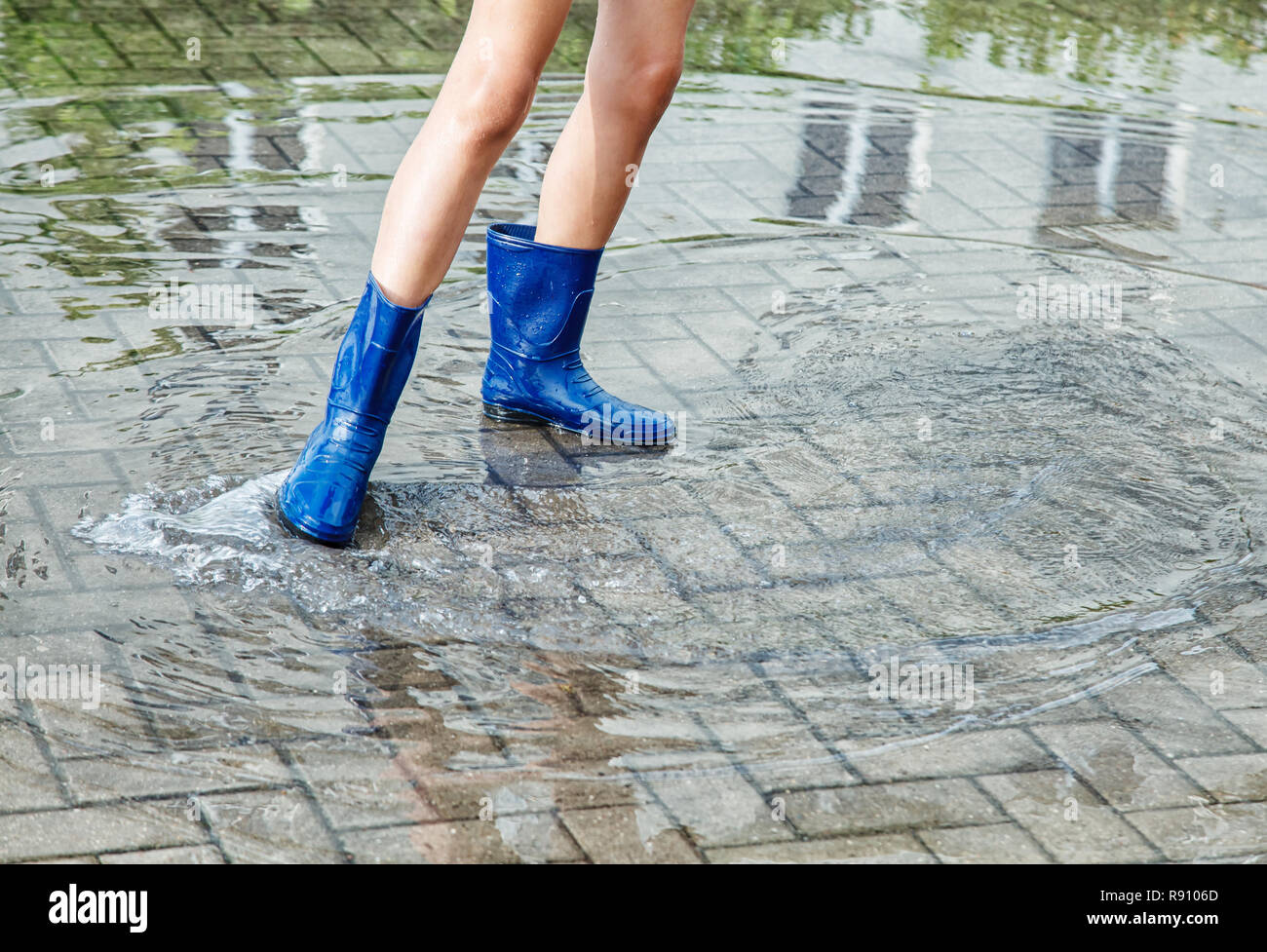 Mädchen in Gummistiefel in einer Pfütze stehen nach einem Regen im Sommer im  Freien Tag. Beine closeup Stockfotografie - Alamy