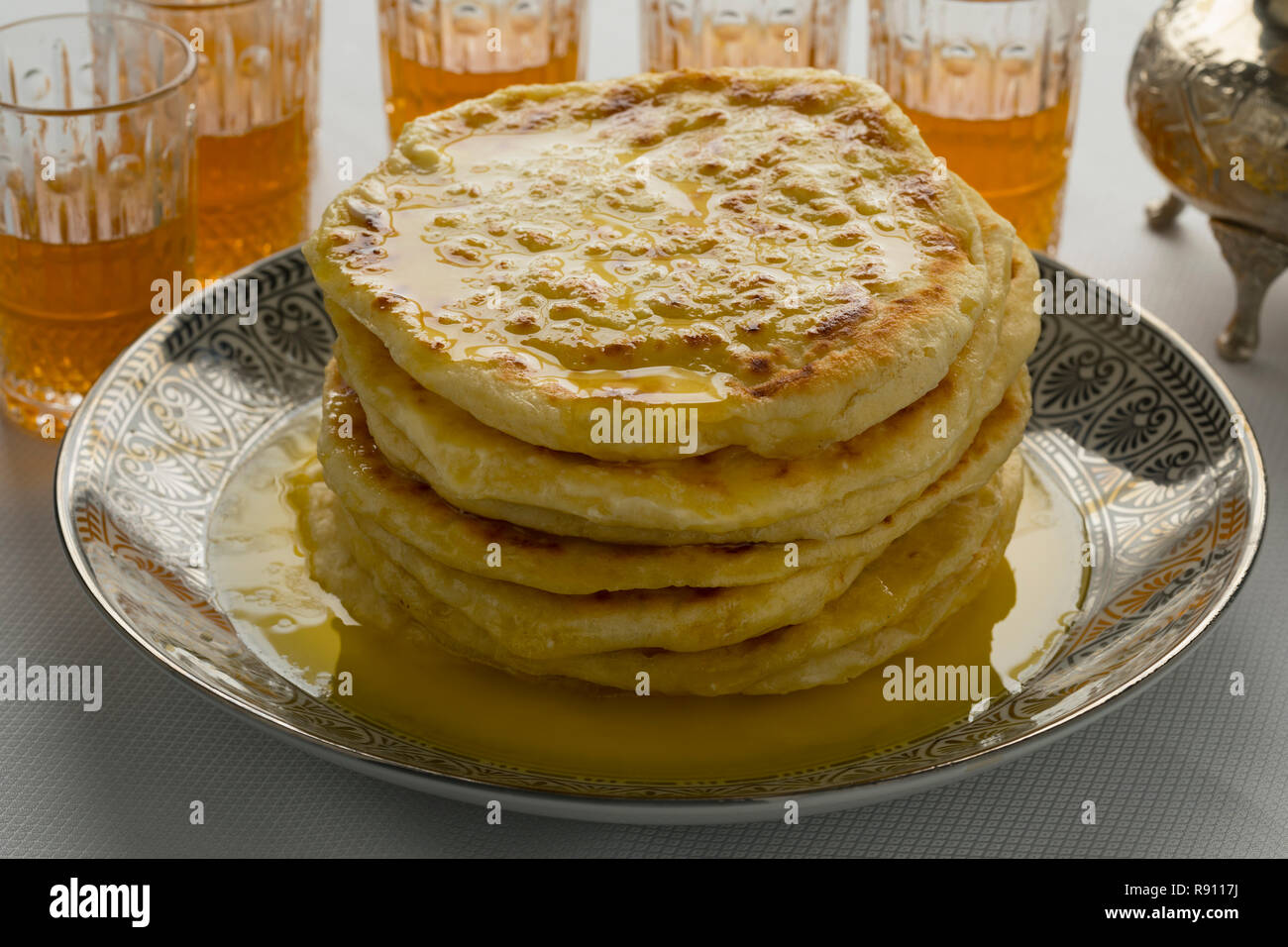 Stapel von traditionellen marokkanischen meloui Pfannkuchen gefüllt mit Butter und Kaffee Gläser Stockfoto