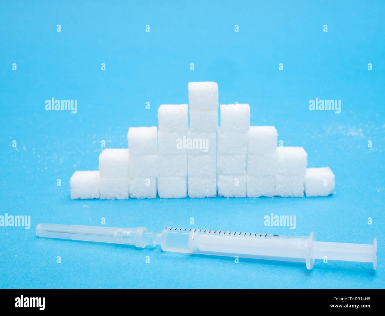 Stapel der weißen Blöcken von Zucker und Spritze mit Insulin Blutzucker Qualität Konzept Stockfoto