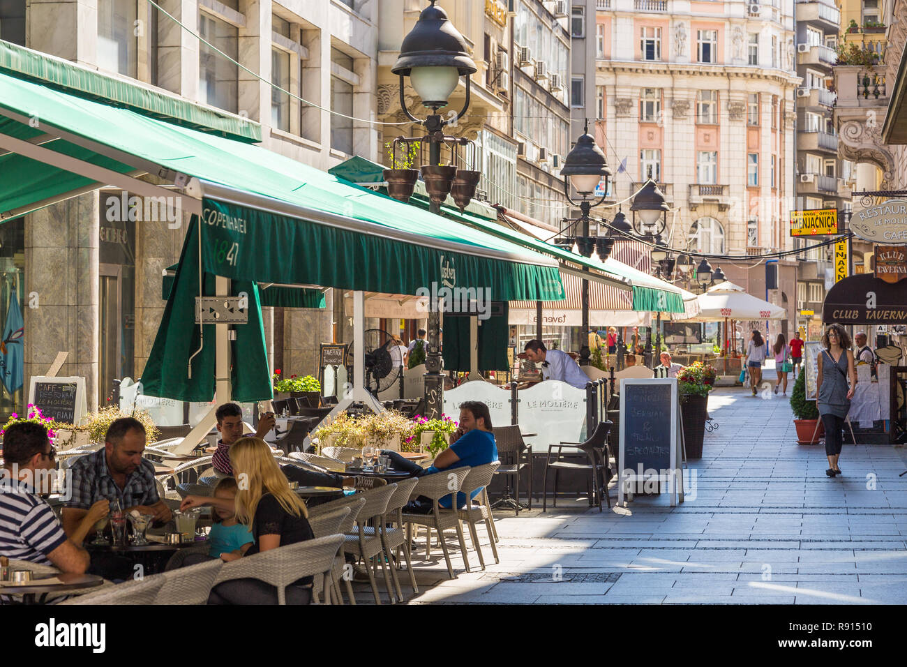 Belgrad, Serbien - 17. August 2014: Restaurants mit Tischen und Sonnenschirmen außerhalb Krajla Petra Straße in der Altstadt. Menschen wandern und Essen. Stockfoto