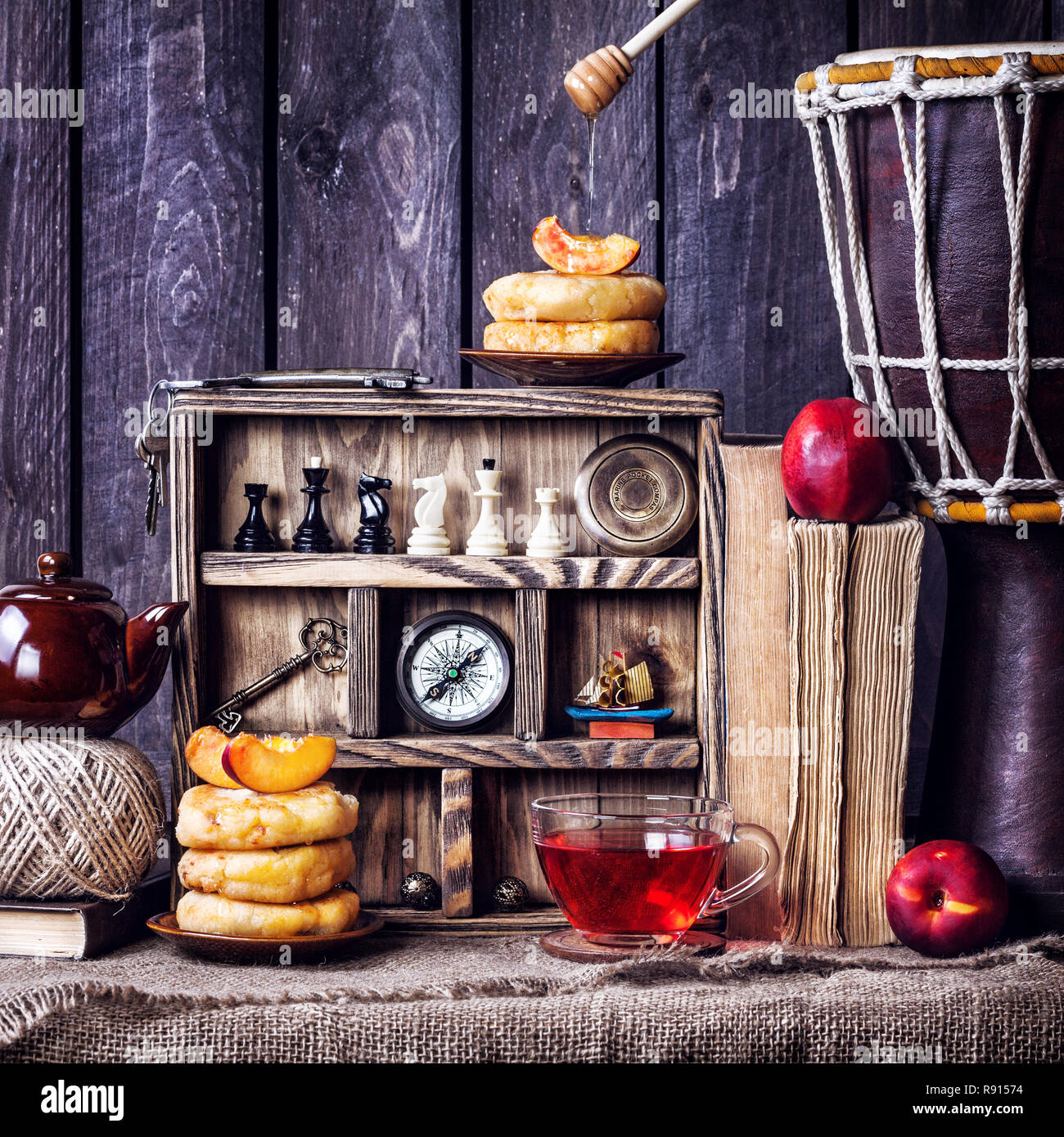 Käse Kuchen mit Honig, Pfirsiche, Hibiskus Tee und traveler Outfit auf dunklem Hintergrund Stockfoto