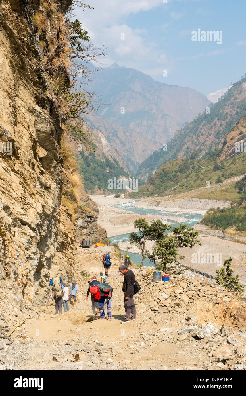 Trekker auf dem Manaslu Circuit Trek in Nepal zu Fuß durch einen Abschnitt der neuen Straße unter constructuion Stockfoto