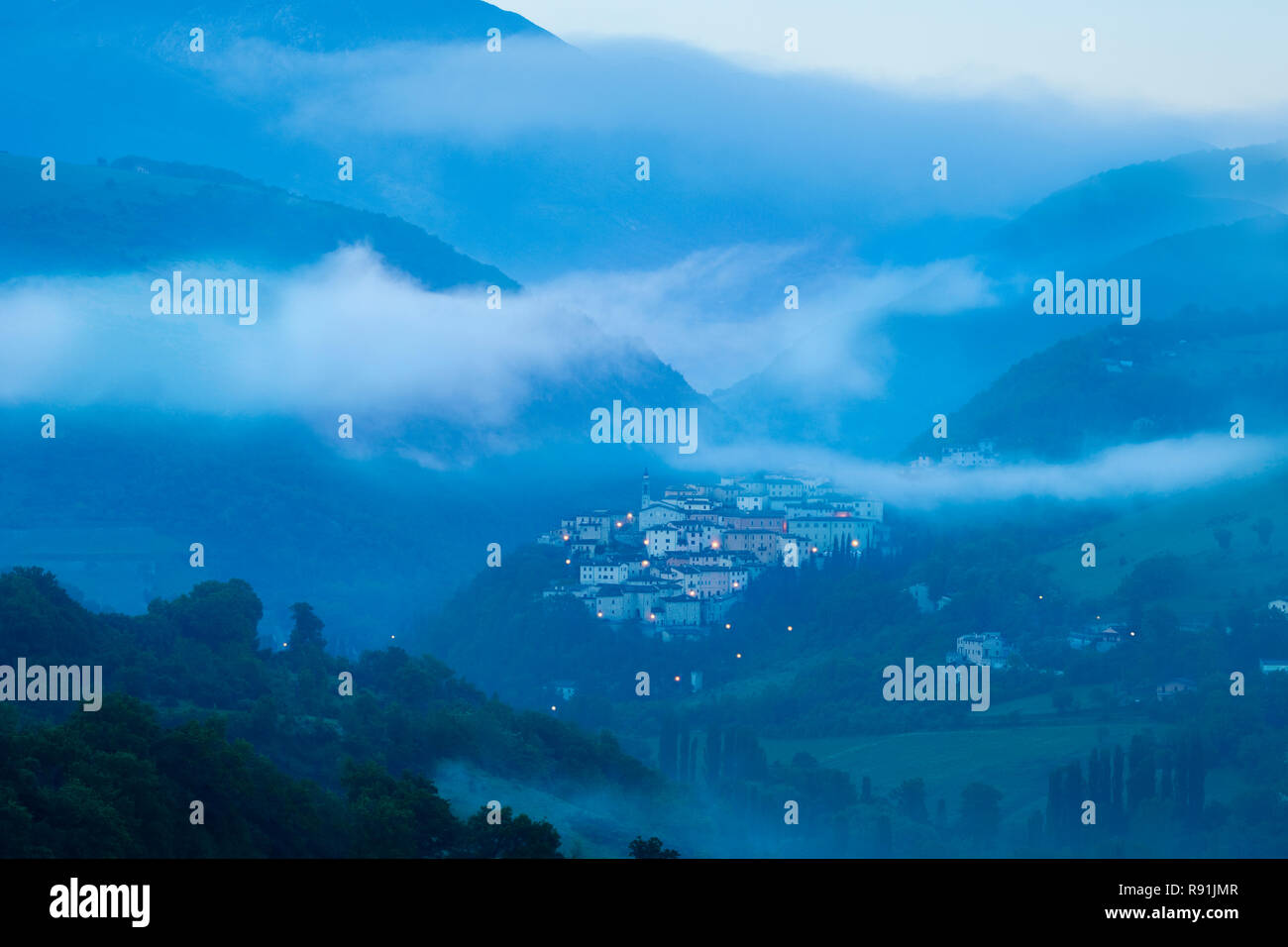Misty Dawn über mittelalterliche Stadt Preci im Nationalpark Monti Sibillini, Umbrien, Italien Stockfoto