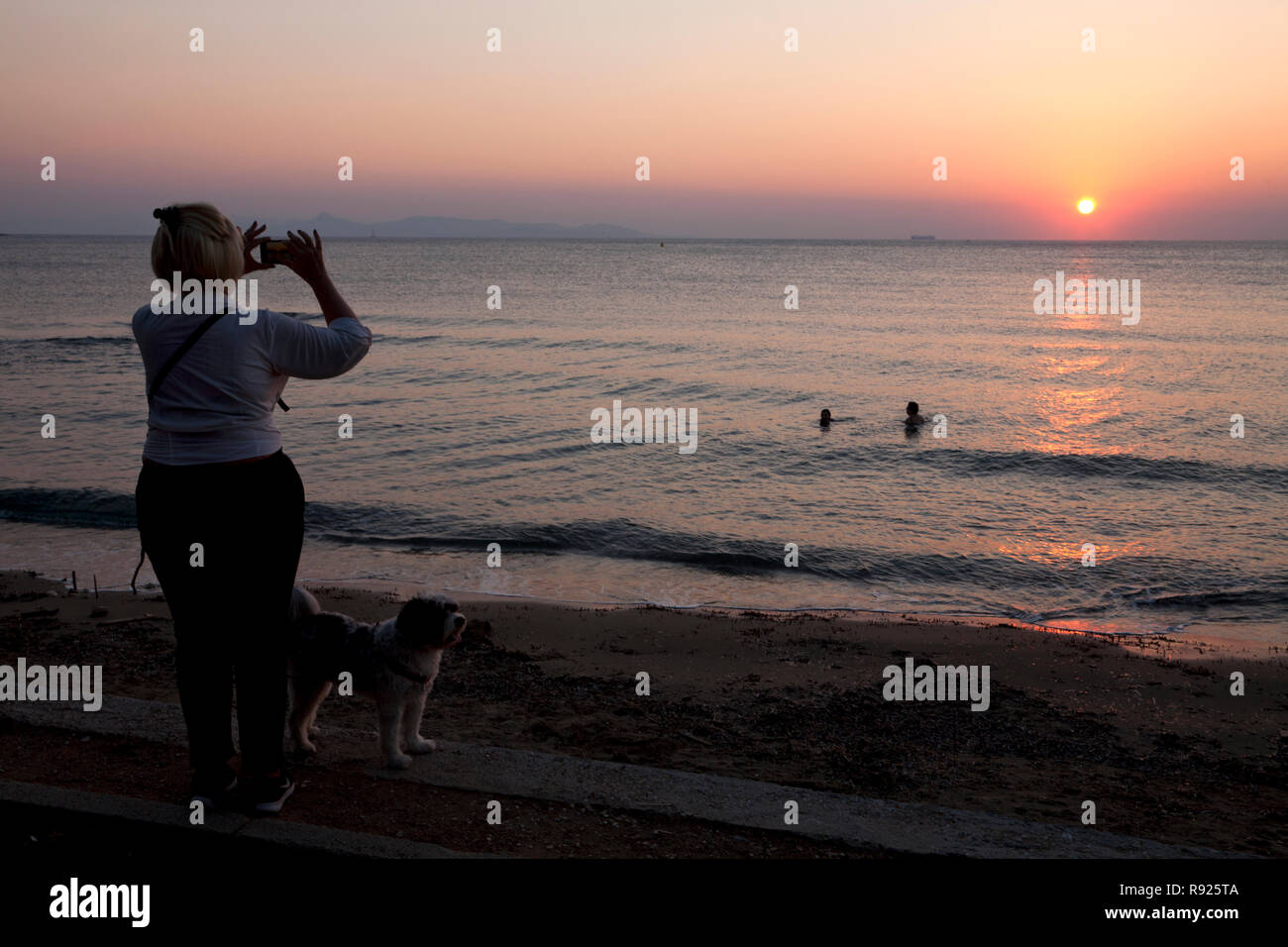 Frau machen Fotos Sonnenuntergang Ägäis vouliagmeni Athens Attica Griechenland Stockfoto