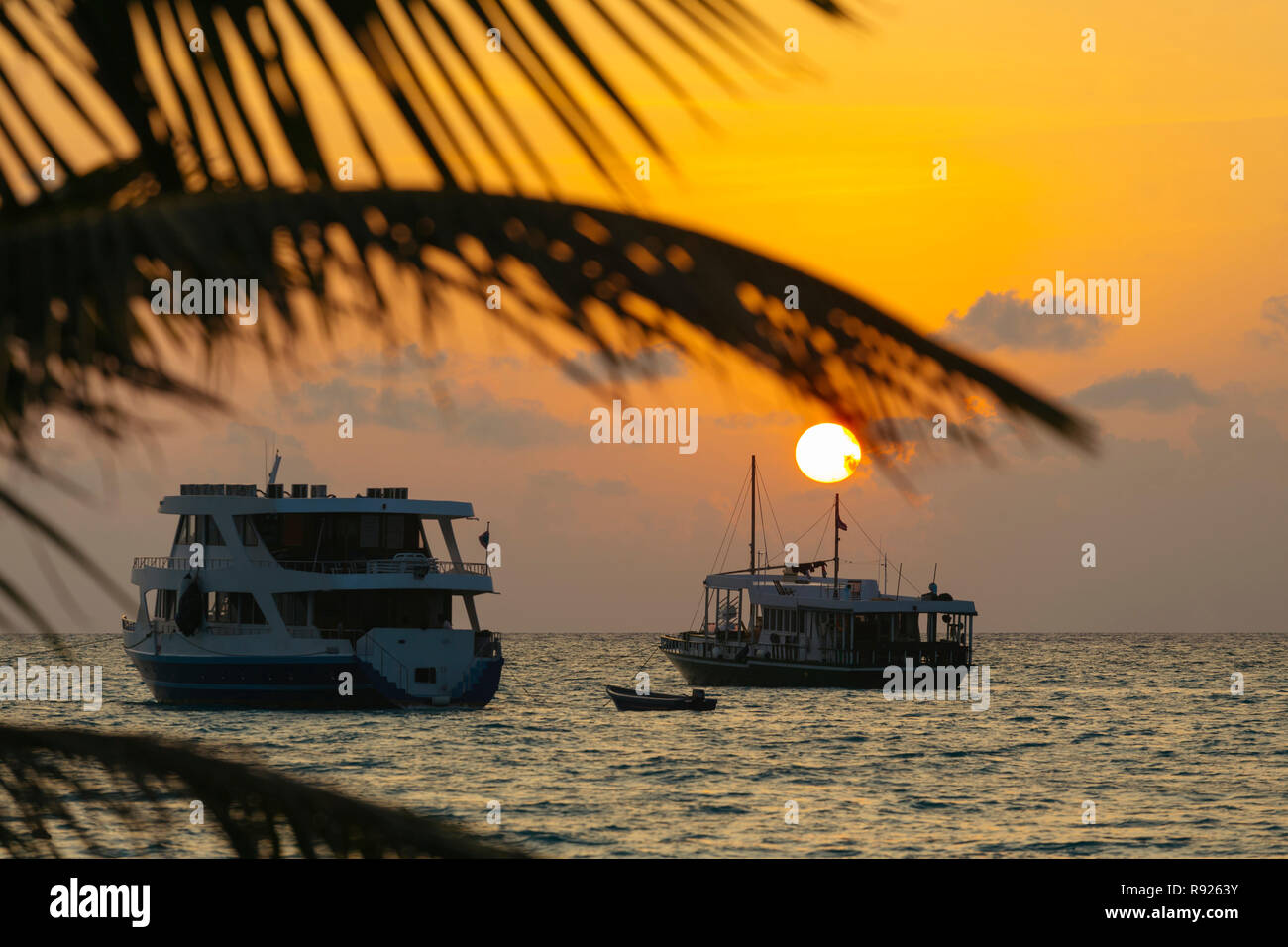 Ruhige Szene mit Blick auf Schiffen, die im Meer bei Sonnenuntergang, Thulusdhoo, Male, Malediven Stockfoto
