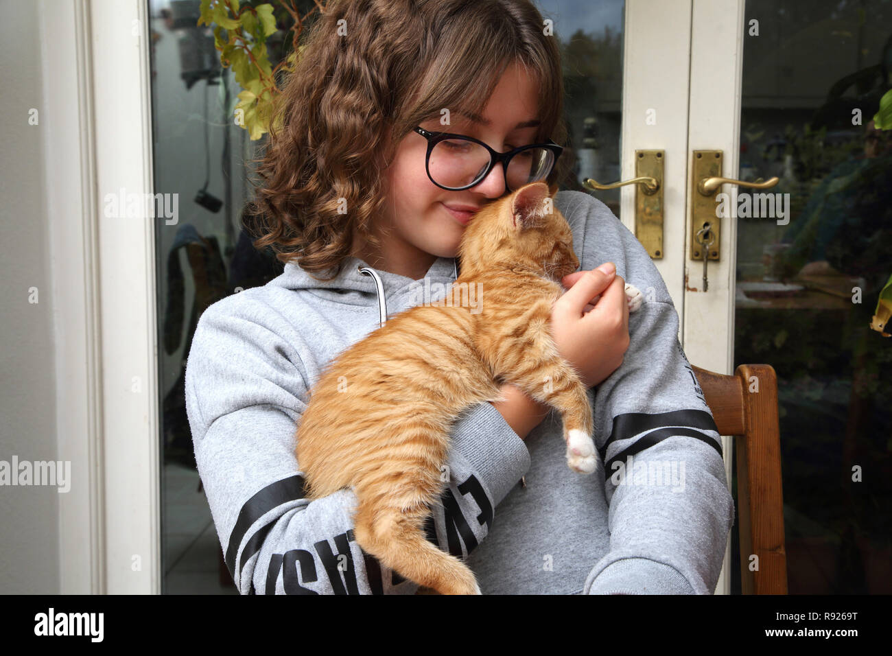 12 Jährige Mädchen mit Ingwer und weiße Katze Surrey, England Stockfoto