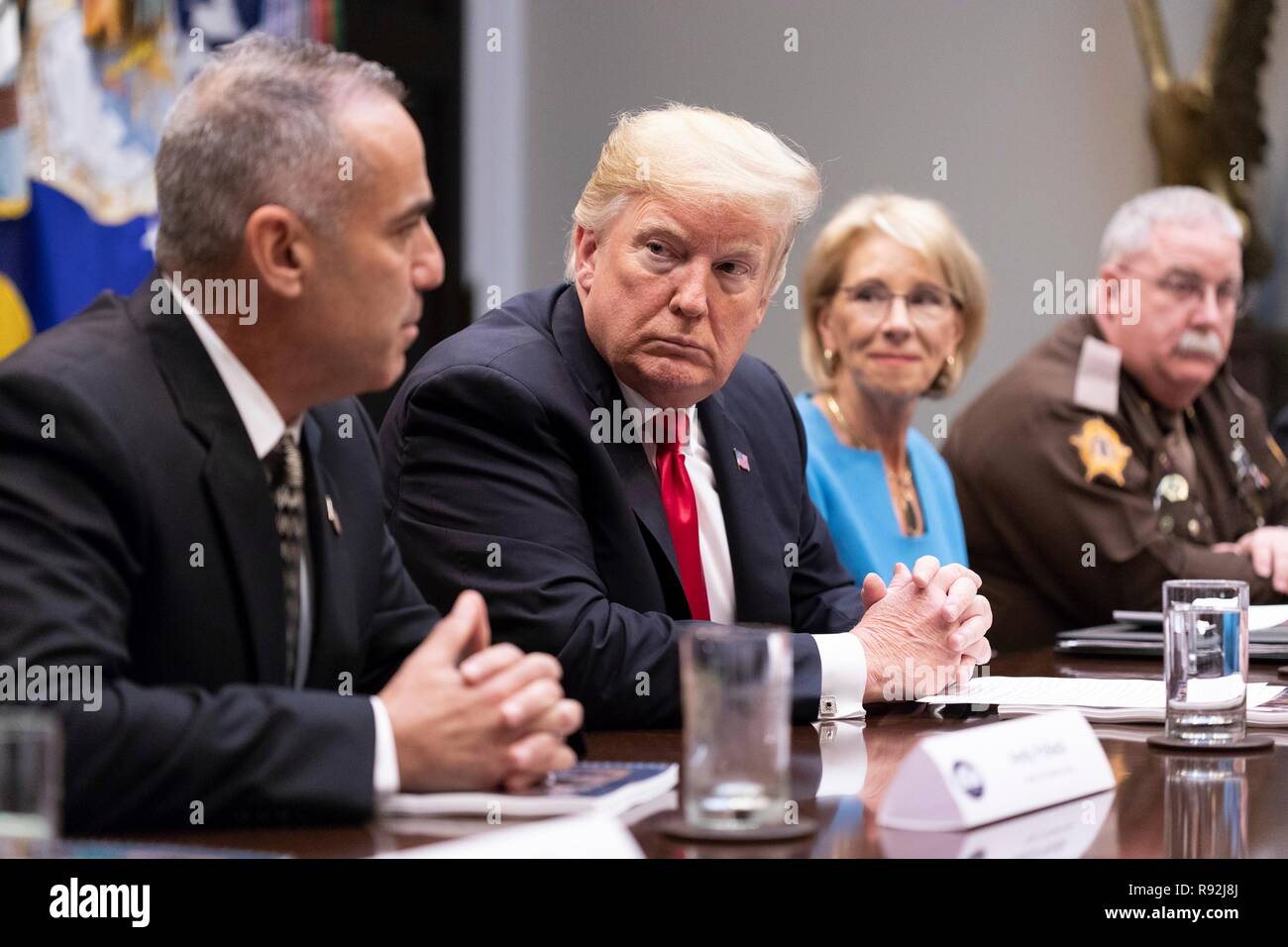 Washington DC, USA. 18. Dezember, 2018. Us-Präsident Donald Trump, Mitte, hört zu, Andy Pollack, der Vater von einem Marjory Stoneman Douglas High School shooting Opfer, Links, während einer Konferenz auf der Schule Safety Report, im Roosevelt Raum des Weißen Hauses zum 18. Dezember 2018 in Washington, DC. Credit: Planetpix/Alamy leben Nachrichten Stockfoto