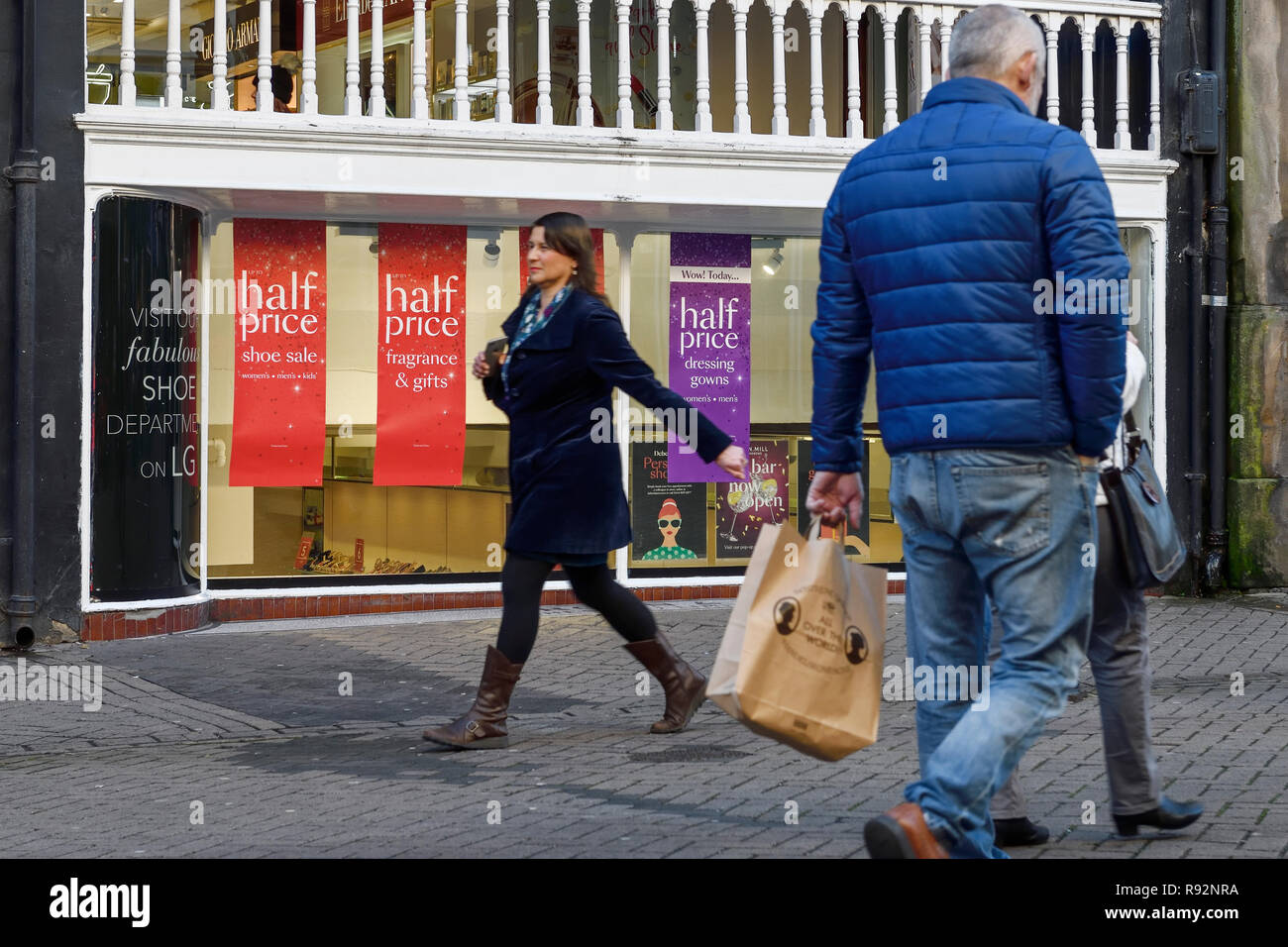 Chester, UK. Dezember 2018 19. Käufer vorbei an city center shop Fenster angezeigt wird und weniger als eine Woche bis Weihnachten viele Einzelhändler schwer lieferbar sind Diskontierung. Credit: Andrew Paterson/Alamy leben Nachrichten Stockfoto