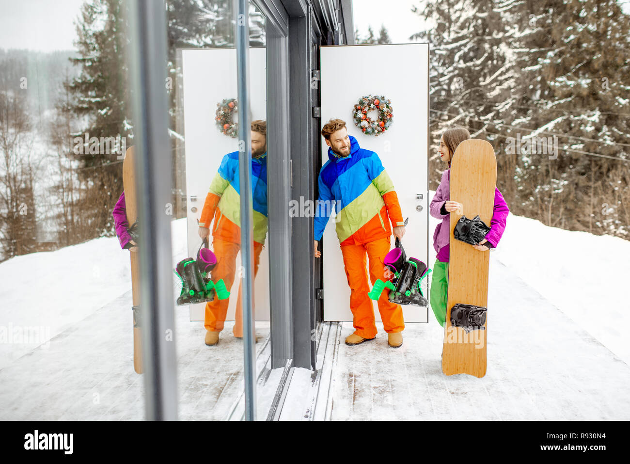 Junges Paar in coloful Skianzuege Eingabe von zu Hause oder im Hotel nach dem Snowboarden in den Snowy Mountains Stockfoto