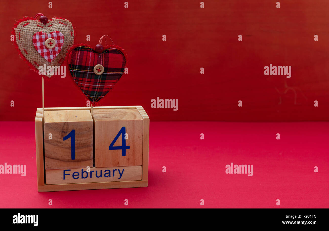 Valentines Tag. Kalender Holzwürfel mit 14. Februar Text und zwei roten  Stoff Herz, gegen den roten Hintergrund, Kopie Raum Stockfotografie - Alamy